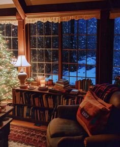 a living room filled with furniture and a christmas tree in front of a large window