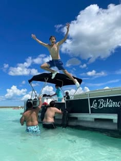 a man jumping into the water from a boat