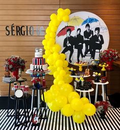 a party with yellow balloons and black and white striped tablecloths on the floor