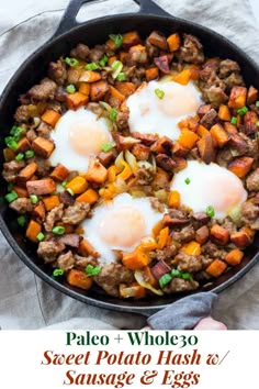 two eggs are being cooked in a skillet with sausage and sweet potato hash browns