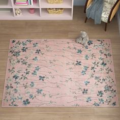 a pink rug with blue flowers on it in a child's playroom area