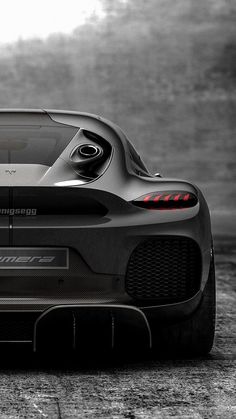 the rear end of a sports car in black and white