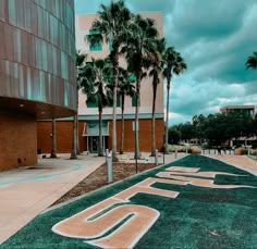 a building with palm trees in front of it and the number ten painted on the ground