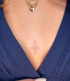 a woman's chest with a small star tattoo on it