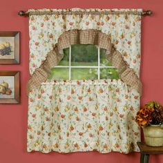 a window with a flowered curtain and potted plant next to it on a table