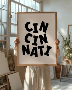 a woman holding up a sign that says cin'n nati