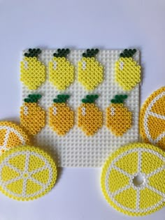 the beaded coasters are decorated with lemons and oranges on white background