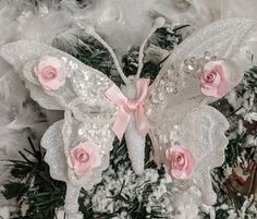 a white and pink butterfly ornament with roses on it