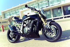 a black and silver motorcycle parked in front of a building