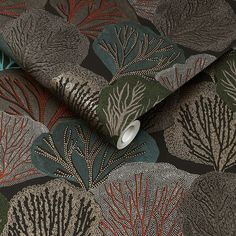 a close up view of a wallpaper design with leaves and plants on black background