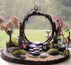 an outdoor garden with rocks and flowers on the ground, in front of a window