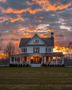 a large white house sitting on top of a lush green field under a cloudy sky