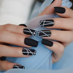 a woman's hands with black and white nail polish