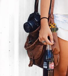 a person holding a camera and a bottle