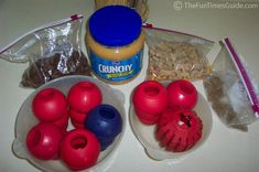 some plastic toys are sitting on a table next to other items and food in bowls