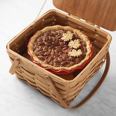 a pecan pie in a wooden basket on a white counter top with a chain attached to it