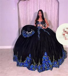 a woman in a black and blue dress posing for the camera