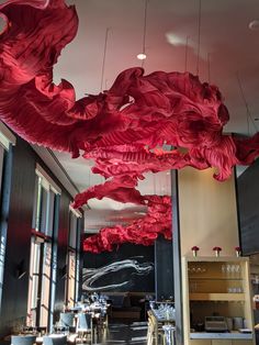 the restaurant is decorated with red paper flowers hanging from the ceiling and tables in front of them