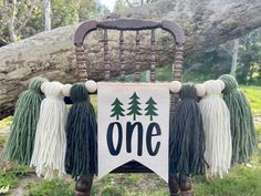 a chair decorated with tassels and a one sign hanging from it's back