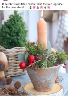 a candle that is sitting on top of a table with pine cones and other decorations