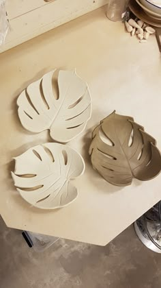 three white plates sitting on top of a counter next to each other in front of a sink