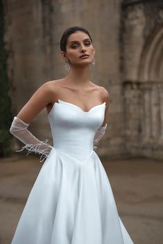 a woman in a white dress posing for the camera