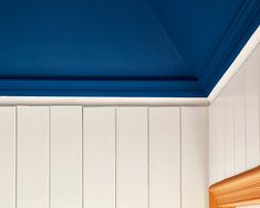 a bathroom with blue painted ceiling and white walls