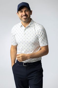 a smiling man in a white shirt and blue pants with a cap on his head