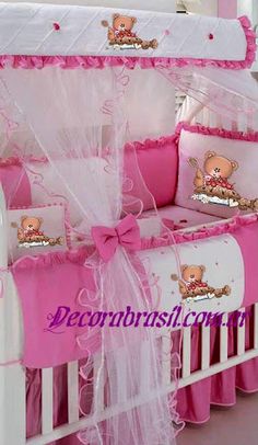 a baby crib with pink and white bedding, teddy bear pillowcases and bumper covers