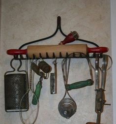 an assortment of kitchen utensils hanging on a wall