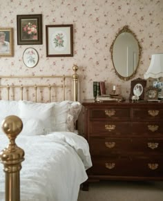 there is a bed and dresser in this room with floral wallpaper on the walls