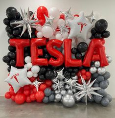 a balloon sculpture with the word tesla surrounded by balloons and stars