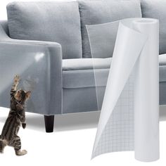 a cat is playing with a large white piece of furniture next to it's scratching post