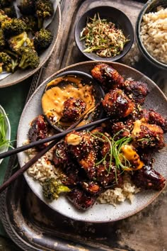 a plate full of food with chopsticks and sauce on it next to other dishes