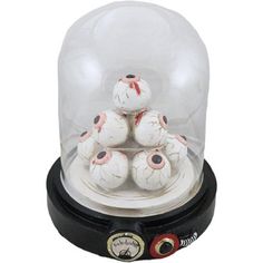 a display case filled with lots of white balls inside of a glass dome on top of a black stand