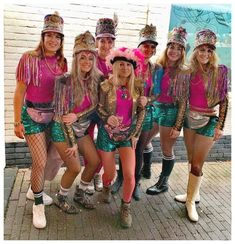 a group of women dressed in colorful outfits posing for a photo with one woman wearing a pink shirt and green shorts