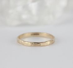 a gold wedding band on a white background