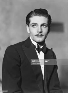 an old black and white photo of a man in a tuxedo with a mustache