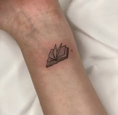 a small book tattoo on the wrist