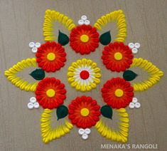 a colorful flower design made out of yarn on a wooden surface with white and yellow flowers