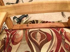 an old wooden chair is sitting on the floor next to some tools and other items