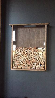 a wooden frame with wine corks in it hanging on the wall above a bed