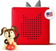 a red radio with a dog figurine next to it and an american flag sticker