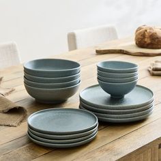 a table topped with plates and bowls on top of a wooden table