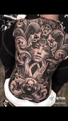 the back of a woman's body with an intricate tattoo design on her stomach