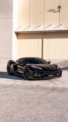 a black sports car parked in front of a building