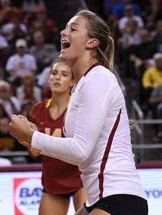 a female volleyball player is celebrating her team's victory