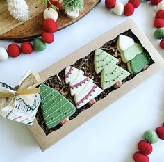 decorated christmas cookies in a box on a table