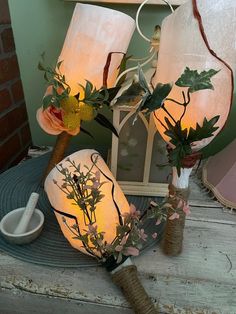 a table topped with vases filled with flowers next to a lamp and other items