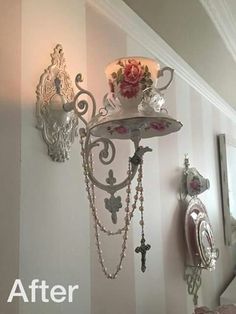 a chandelier hanging from the side of a white wall next to a mirror